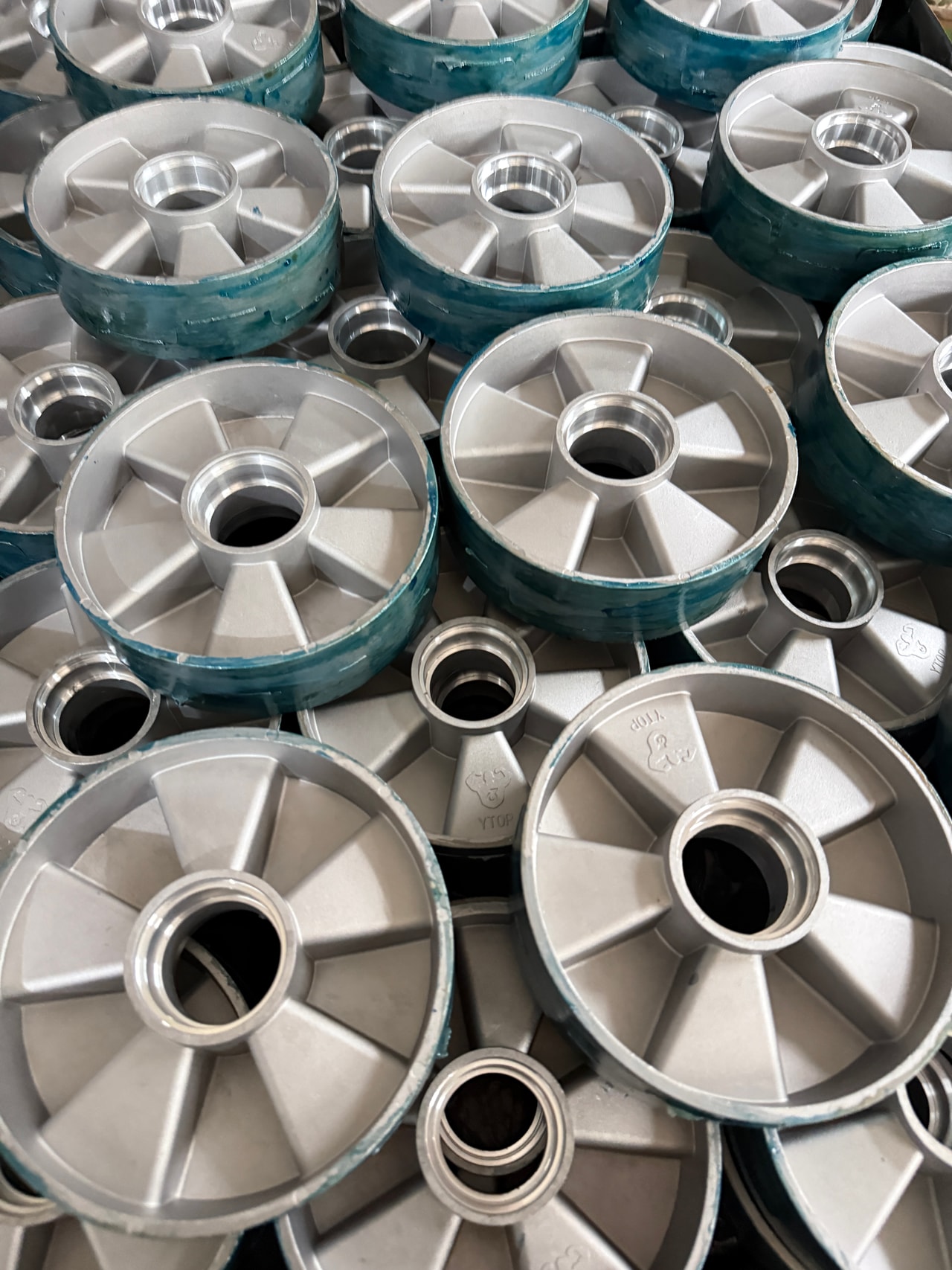 Batch of metal wheel cores with machined bores and reinforcing ribs before polyurethane casting